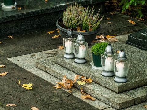 Monument en granit avec semelle, fleurs et bougies